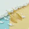 Handmade sterling silver angel wing earrings showing detailed openwork filigree design