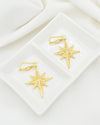 Gold North Star celestial filigree dangle earrings worn on woman ear
