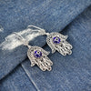 Handmade sterling silver filigree Hamsa earrings featuring blue evil eye design